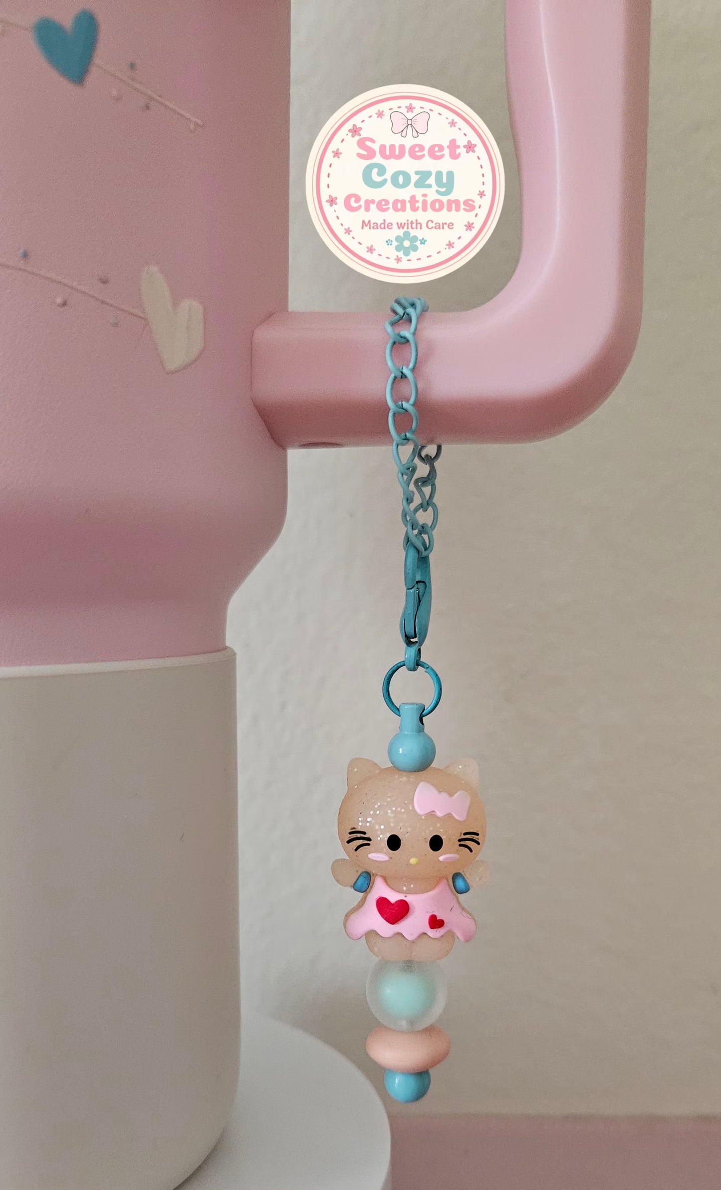 Kitty Tumbler Charm sitting on a blue bead